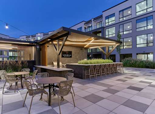 A patio with a bar and chairs is set up outside a building.