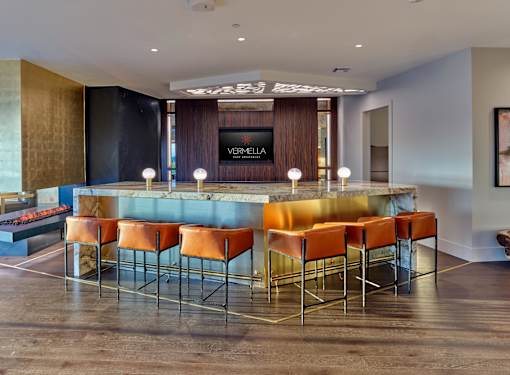 A bar with orange chairs and a counter with a sign that says