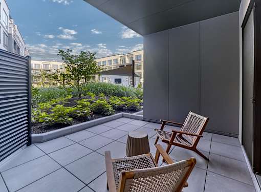 A patio with two chairs and a table with a view of the sky.