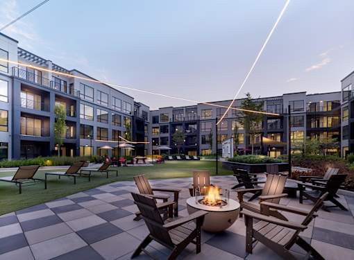 A modern building with a fire pit in the foreground.
