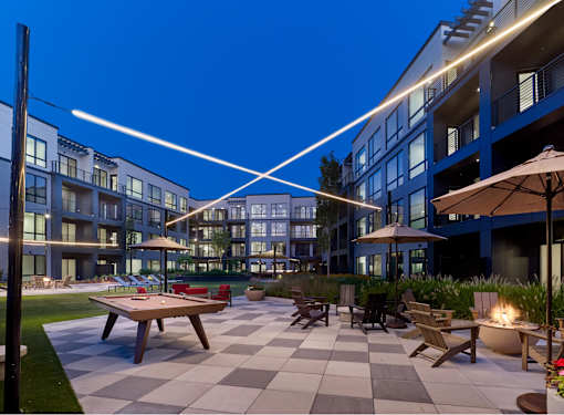 A modern outdoor seating area with a checkered floor and a fire pit.