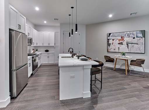 A modern kitchen with a white island and stainless steel appliances.