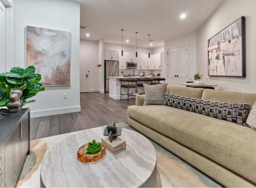 A modern living room with a couch, coffee table, and artwork on the walls.