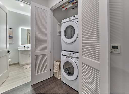 A white washing machine is in a small laundry room.