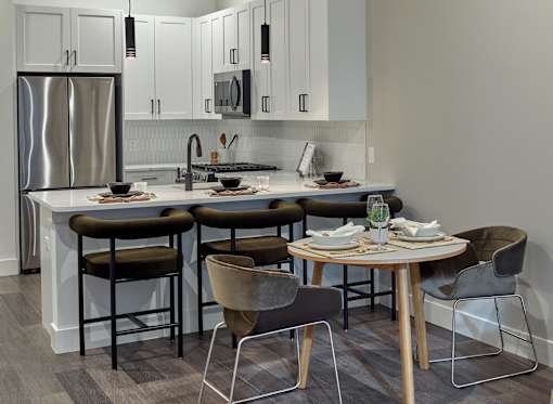 A modern kitchen with a table set for two.