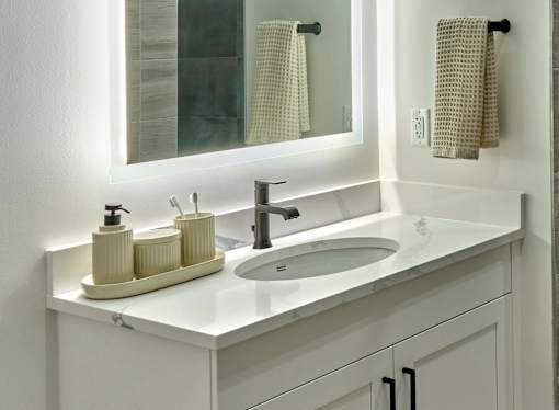 A white bathroom sink with a tray of toiletries on the counter.