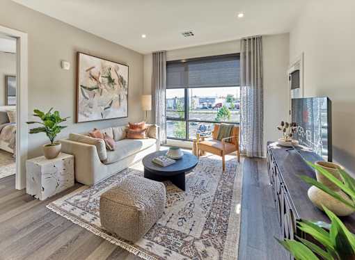 A living room with a couch, coffee table, and a painting on the wall.
