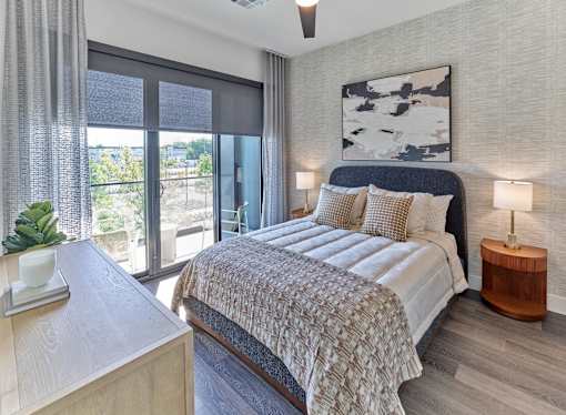 A bedroom with a large bed and a view of the outdoors through the window.