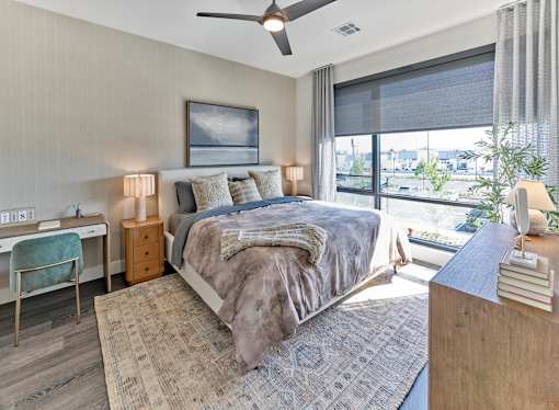 A bedroom with a large bed, a desk, and a chair.