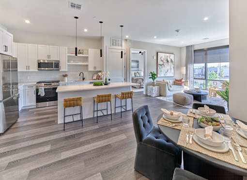 A modern kitchen with a dining table set for four.
