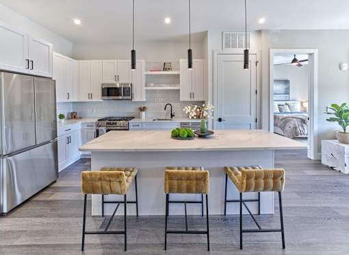A modern kitchen with a large island and bar stools.