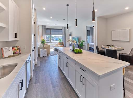 A modern kitchen with white cabinets and a marble countertop.