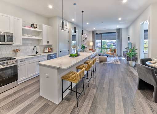 A modern kitchen with a large island and bar stools.