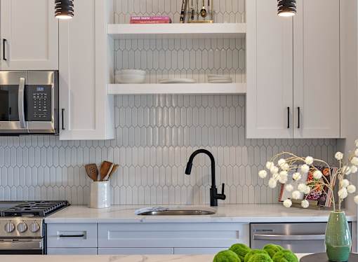 A kitchen with white cabinets and a black stove top.