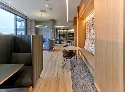 A modern office space with a long wooden table and chairs.