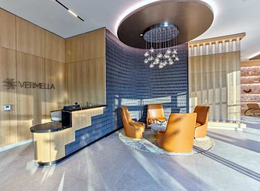 A reception area with orange chairs and a wooden counter.