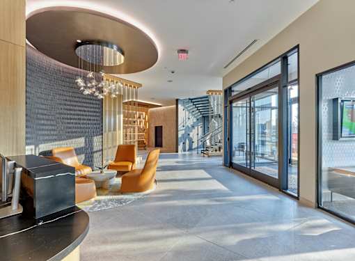 A modern interior space with a curved ceiling, a staircase, and a reception desk.