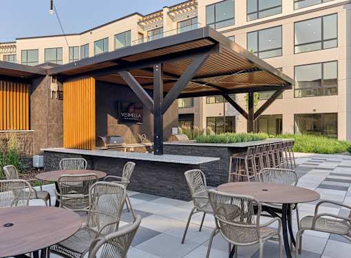 A patio with tables and chairs and a building in the background.