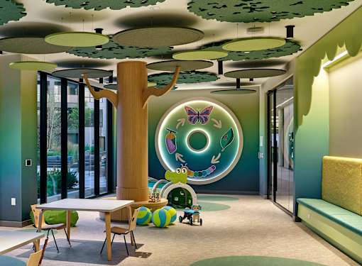 A room with a green wall and a tree-like structure in the middle.