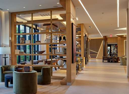 A long hallway with a lot of seating and a large window.