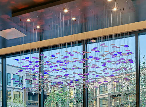 A modern interior with purple and blue decorative elements hanging from the ceiling.