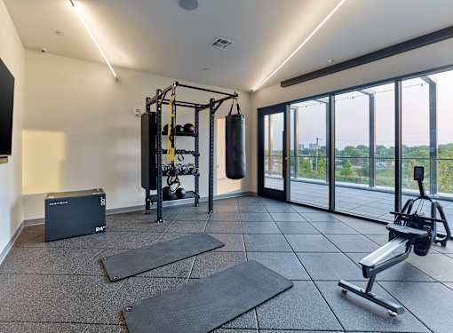 A home gym with a punching bag, weight rack, and exercise equipment.