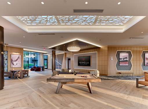 A room with a pool table and a TV mounted on the wall.