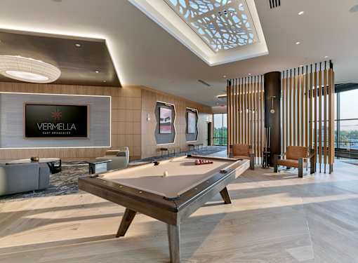 A pool table in a room with a Vermella sign on the wall.