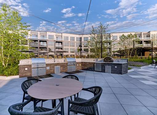 A patio with a table and chairs is in front of a building.