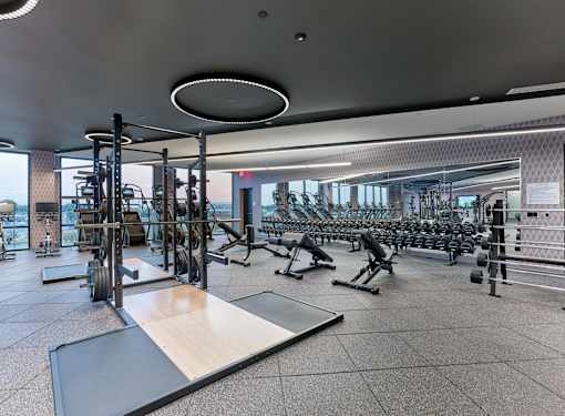 A gym with a variety of equipment including weights and weight machines.