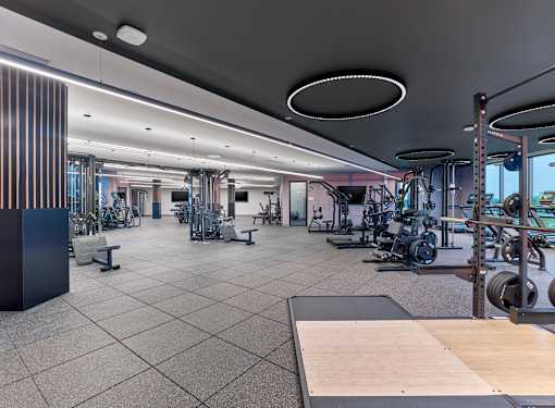 A gym with a variety of equipment including weights and cardio machines.