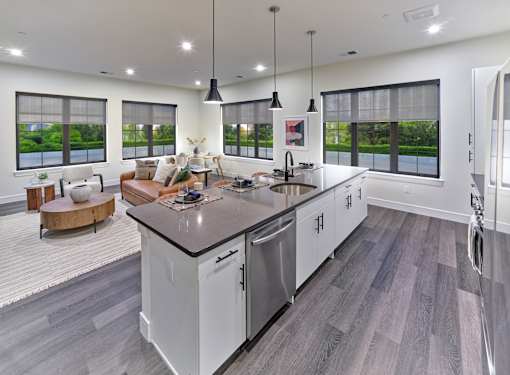 A modern kitchen with a large island and a view of the outdoors.