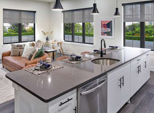 A modern kitchen with a large island and a view of the backyard.