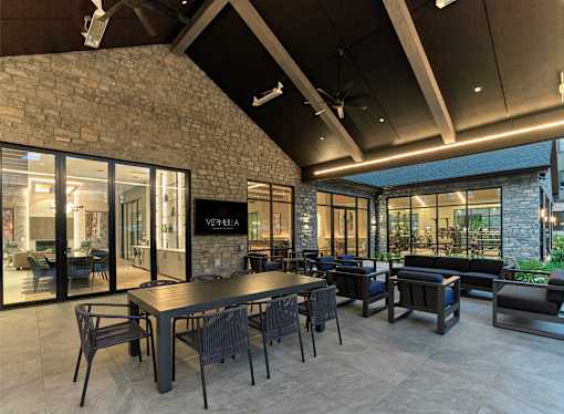 A modern dining area with a stone wall and glass doors.