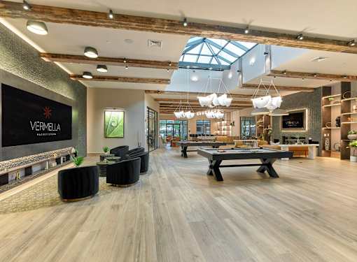 A spacious room with a pool table and a skylight.