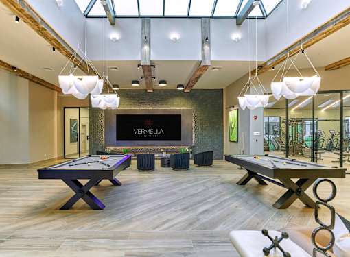 A room with a pool table and a foosball table.