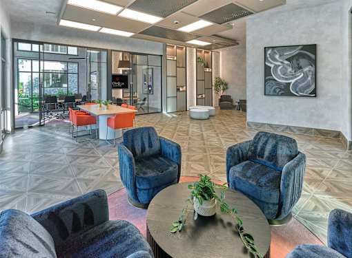 A modern living room with blue chairs and a coffee table.