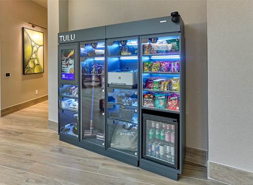 A TULU vending machine with a variety of snacks and drinks inside.
