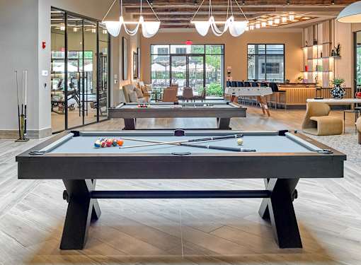 A pool table in a room with a view of the outside.
