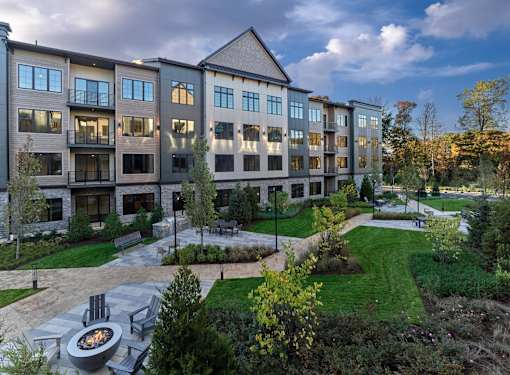 A modern apartment complex with a fire pit in the courtyard.