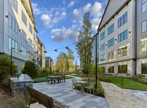 A patio with a table and chairs is surrounded by buildings.