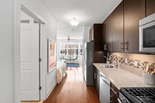 A kitchen with brown cabinets and a black refrigerator.