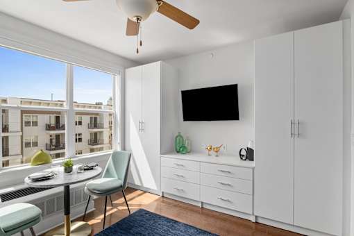 A room with a table, chairs, and a television.