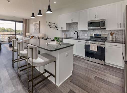 A modern kitchen with white cabinets and a large island.