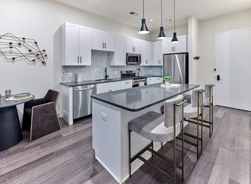 A modern kitchen with a large island and stainless steel appliances.
