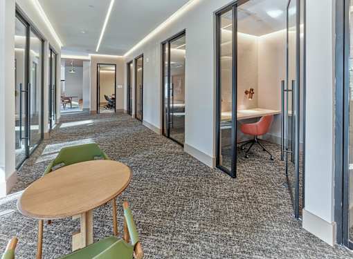 A long hallway with a table and chairs on the left side.