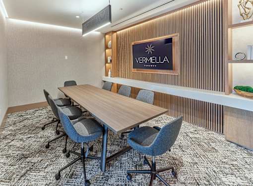 A conference room with a VERMELLA sign on the wall.
