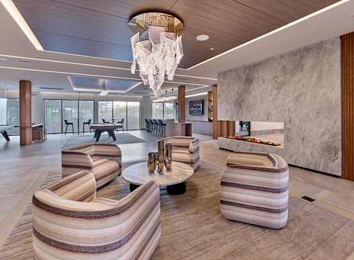 A modern living room with a striped sofa and a chandelier.