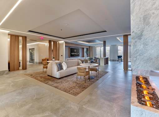 A modern living room with a stone floor and a stone wall.