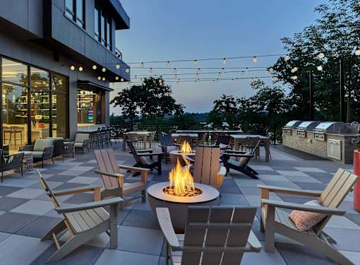 A patio with chairs and a fire pit.